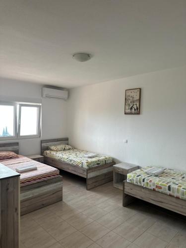 a room with three beds and a table at Benelux Šušanj in Bar