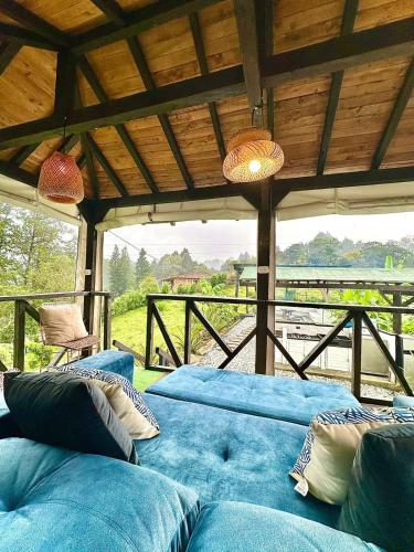 a living room with blue couches and a large window at Cabaña Blanca Guarne cerca a Metrocable ARVI in Guarne
