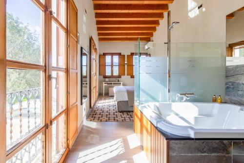 a bathroom with a tub and a large window at Hotel Castell de la Solana in Alcalalí