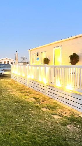 a fence in front of a house with lights at The Beach House East Mersea in Mersea Island