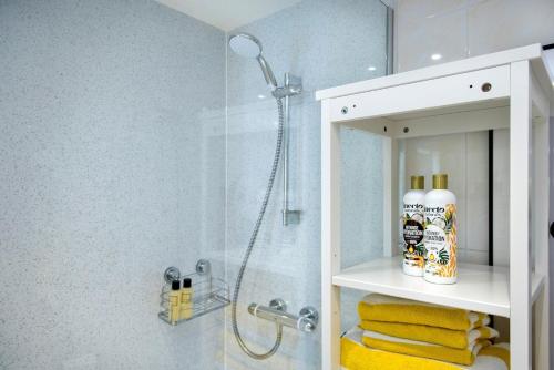 ein Badezimmer mit einer Dusche mit gelben Handtüchern darin in der Unterkunft Waterfront Cottage - Apple Pie Luxury Escapes in Calstock