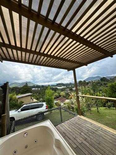 a bath tub sitting under a wooden pergola at Cabaña Carmen de Viboral in Carmen de Viboral