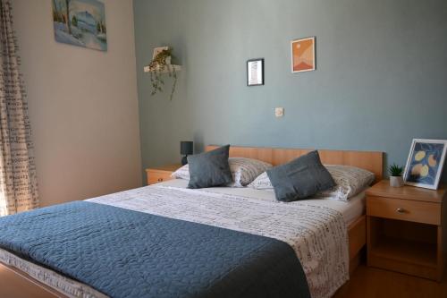 a bedroom with a bed with a blue comforter at Apartment & Rooms Marigold in Baška Voda