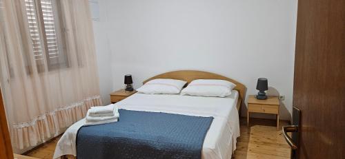 a bedroom with a bed with a blue blanket on it at Apartment Stanisic in Korčula