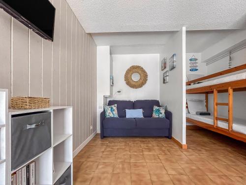 - un salon avec un canapé bleu et des lits superposés dans l'établissement Escapade ensoleillée à Saint-Cyprien, à Saint Cyprien Plage