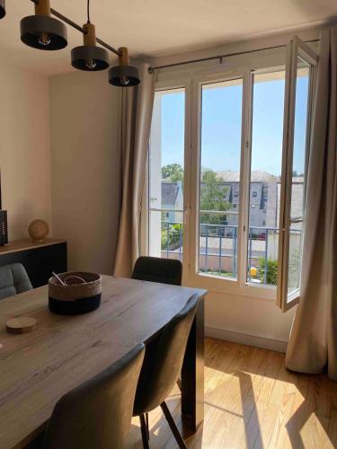 une salle à manger avec une table et une grande fenêtre dans l'établissement Appartement centre-ville Quimper, à Quimper