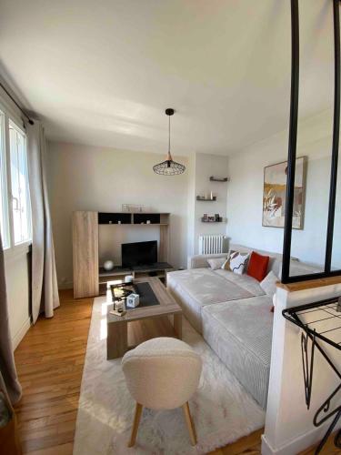 un salon avec un canapé blanc et une table dans l'établissement Appartement centre-ville Quimper, à Quimper