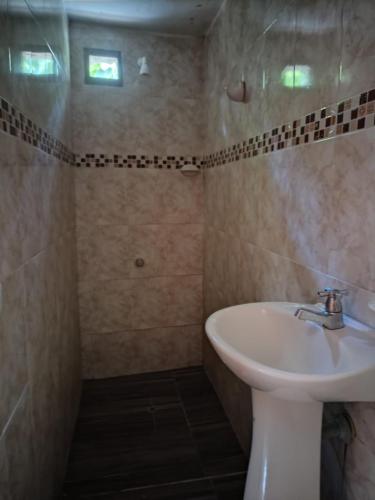 a bathroom with a white sink and a shower at Las Cascadas Hostel in Buritaca