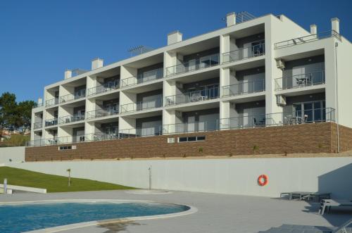 an apartment building with a pool in front of it at Cazenn Nazaré - Apartment Z in Nazaré