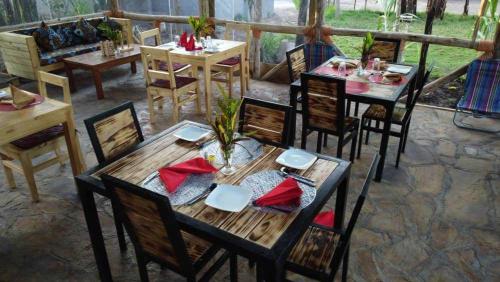 a wooden table and chairs in a restaurant at Jangwani River View Suits in Mto wa Mbu