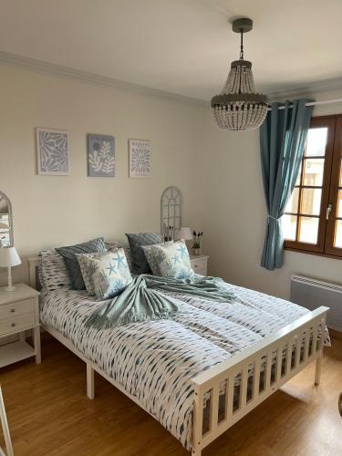 une chambre avec un grand lit avec des rideaux bleus dans l'établissement Villa Rose, à Graignes