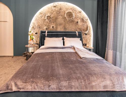 a bedroom with a large bed with a wooden headboard at MoonLight Lofts APHRODITE & POSEIDON in Alexandroupoli