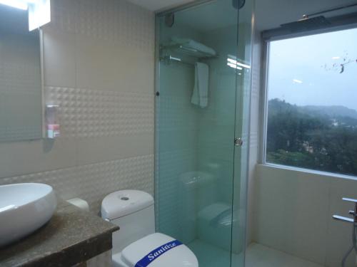 ein Badezimmer mit Dusche, Toilette und Waschbecken in der Unterkunft Neeshorgo Hotel & Resort in Cox's Bazar