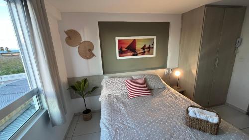 a bedroom with a bed with red and white pillows at Flat Tambaú - Beira-mar in João Pessoa