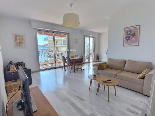 un salon avec un canapé et une table dans l'établissement Bright 2-bedroom & beautiful sea view, à Ajaccio