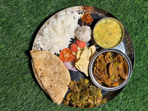 a plate of food with rice and different types of food at Sea Esta Resort - Kashid Beach in Kashid