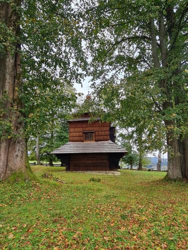 a small brick building in a park with trees at Dwerniczek 7 apartamenty in Dwerniczek