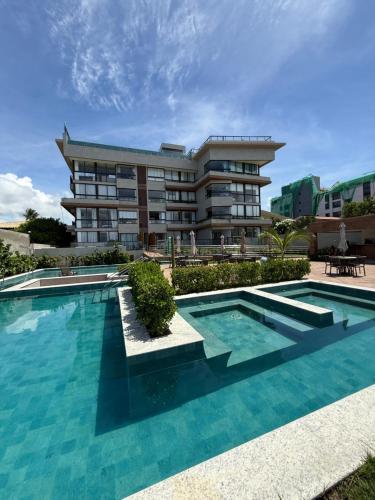 a swimming pool in front of a building at Mirante do porto in Porto De Galinhas