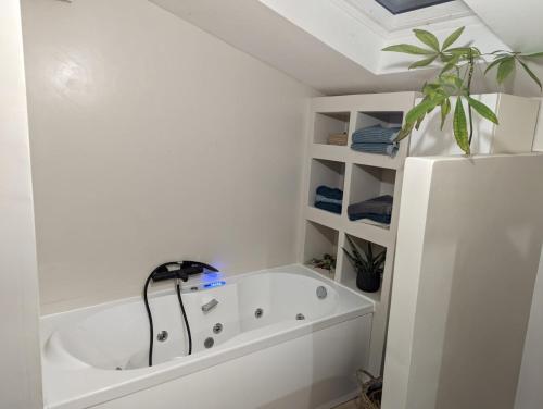 une salle de bain blanche avec une baignoire et un réfrigérateur dans l'établissement Maison de campagne avec piscine, à Mauguio