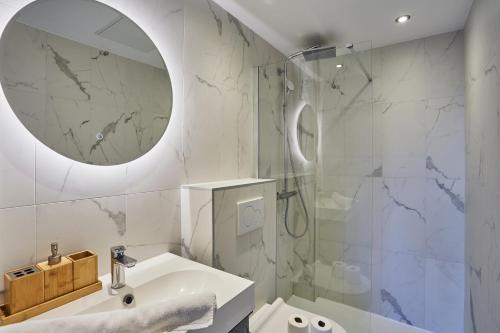 une salle de bain avec un lavabo et une douche avec un miroir dans l'établissement Appartement lumineux dans Paris - Climatisé, à Paris