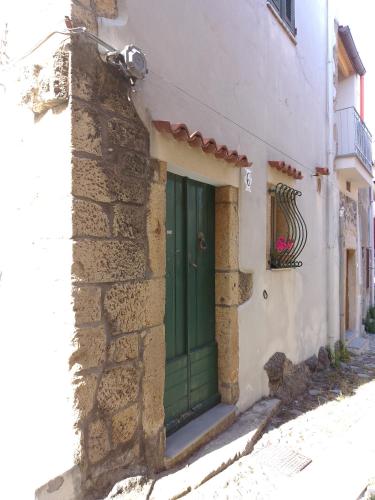 una porta verde sul lato di un edificio di la roccia a Cuglieri