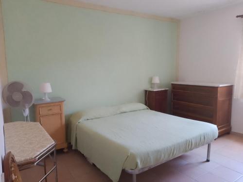 una camera da letto con due letti, un comò e una sedia di la roccia a Cuglieri
