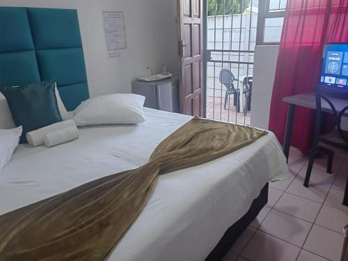 a bedroom with a bed with a blanket on it at MayBach Hills Palace Guesthouse in Saldanha