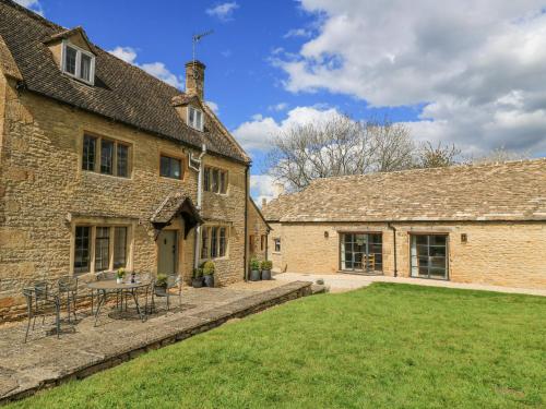 an external view of a building with a table and chairs at The Smithy in Stow on the Wold