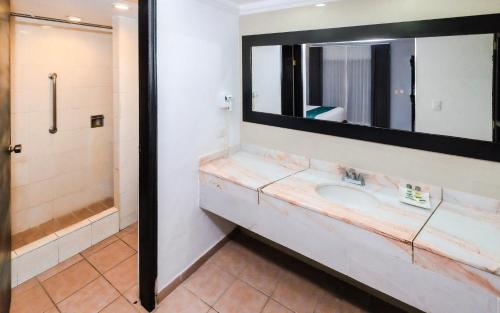 a bathroom with a sink and a mirror at InHouse Select Hacienda Tres Rios Hotel Culiacán in Culiacán