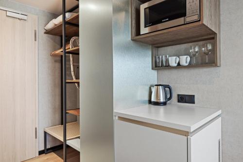 a kitchen with a white counter and a microwave at Boutique Residence Gdańsk in Gdańsk