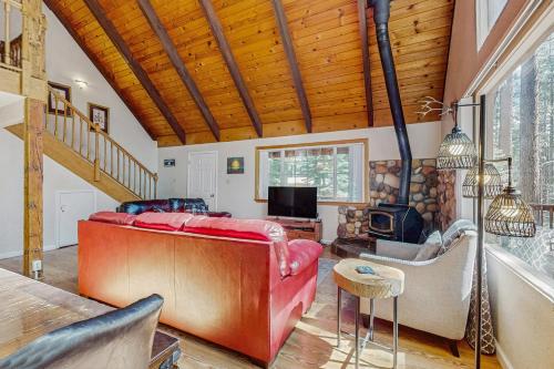 a living room with a red couch and a fireplace at Charming Tahoe Chalet in Tahoe Valley