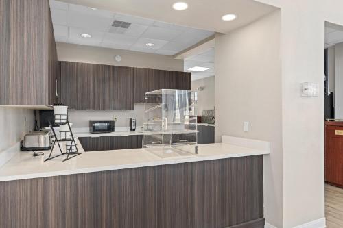 a large kitchen with a counter with a stove at Baymont by Wyndham Orlando East in Orlando