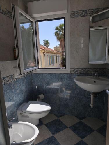 une salle de bain avec toilettes, lavabo et fenêtre dans l'établissement Les Clementines, à Roquebrune-Cap-Martin