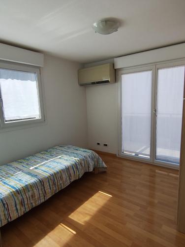 une chambre avec un lit et deux grandes fenêtres dans l'établissement Les Clementines, à Roquebrune-Cap-Martin