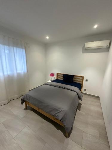 une chambre avec un lit dans une pièce blanche dans l'établissement Villa contemporaine, à Marseille