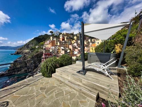 a white chair sitting on a patio overlooking the ocean at Crêuza de Mä in Riomaggiore