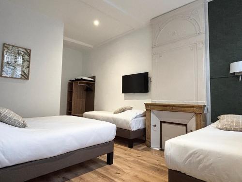 a hotel room with two beds and a fireplace at Hotel Le Jacquemart in Dijon
