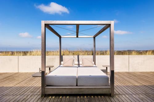 a bed in a canopy on a deck at Duinhotel Tien Torens in Zoutelande