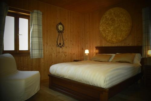 a bedroom with a bed and a clock on the wall at La casa Chiappelle in Cortemilia