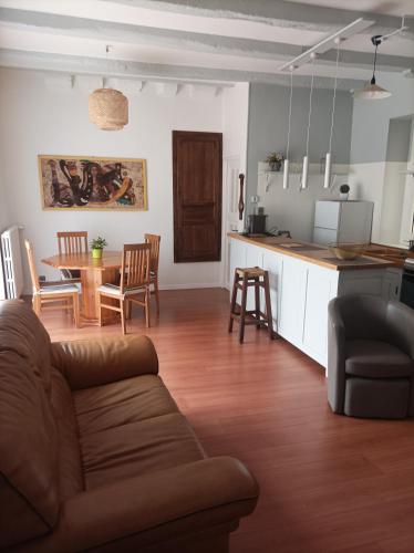 un salon et une cuisine avec un canapé et une table dans l'établissement Maison triplex en centre ville historique, à Cahors
