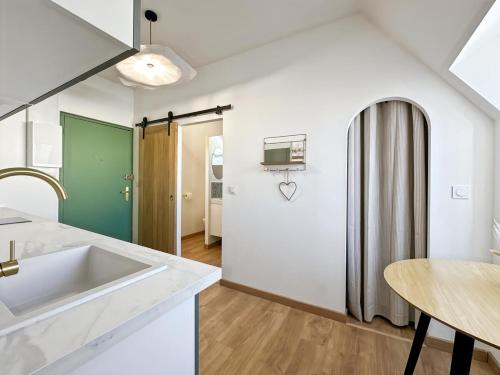 une cuisine avec un évier et un réfrigérateur dans l'établissement Appartement centre ville Concarneau, à Concarneau