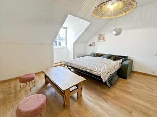 un salon avec un lit et une table dans l'établissement Appartement centre ville Concarneau, à Concarneau