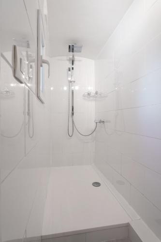 une salle de bain blanche avec une douche et un lavabo dans l'établissement Nice Renting - 5b PENCHIENATTI - Charming Cozy Studio Balcony AC Massena, à Nice