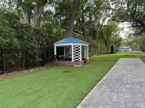 a gazebo with a blue roof in a yard at The Margaret Suite at The Abbey House a B&B in Daytona Beach in Daytona Beach