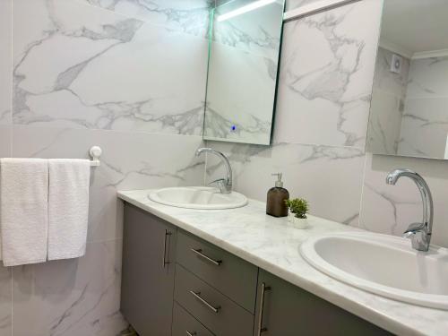 a bathroom with two sinks and a mirror at Aurora Abode in Caldas da Rainha