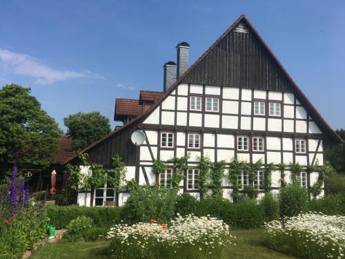 a white house with a black roof at Ferienwohnung auf idyllischer Hofanlage in Lippe in Blomberg