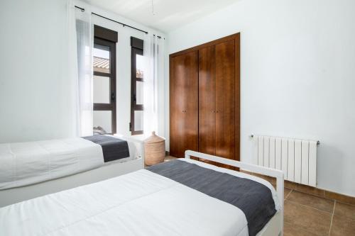 a bedroom with two beds and a window at Villa Siegfried JÁVEA in Benitachell
