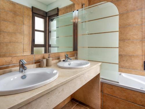 a bathroom with two sinks and a mirror at Villa Siegfried JÁVEA in Benitachell