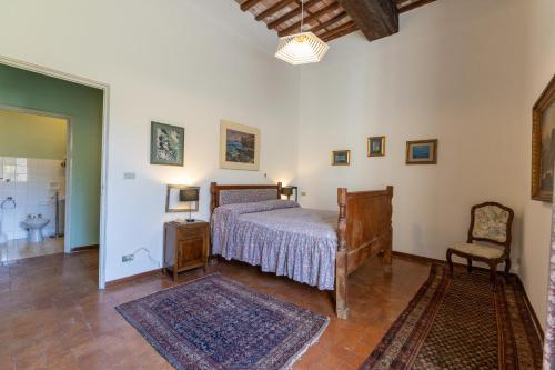 a bedroom with a bed and a chair at Il Casale Di Villa Rossi in Lucca