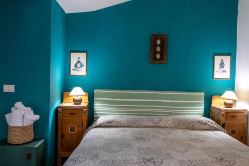 a bedroom with blue walls and a bed with two night stands at Il Casale Di Villa Rossi in Lucca